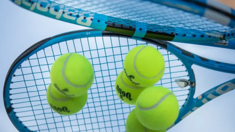Profesjonalna rakieta tenisowa i piłki na korcie przed meczem US Open