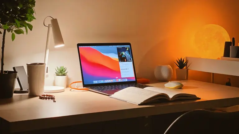 Laptop na biurku przy ciepłym świetle lampy, idealny nastrój na wieczorne planowanie.