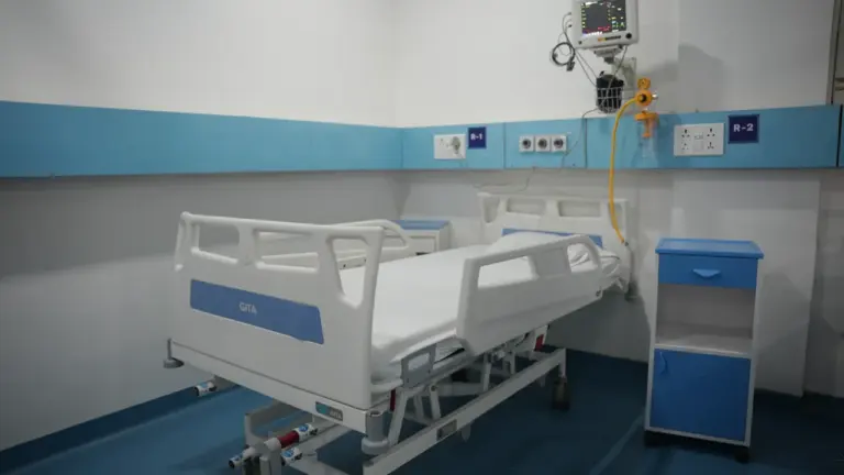 Nowoczesna sala szpitalna z regulowanym łóżkiem oraz niezbędnym sprzętem medycznym.